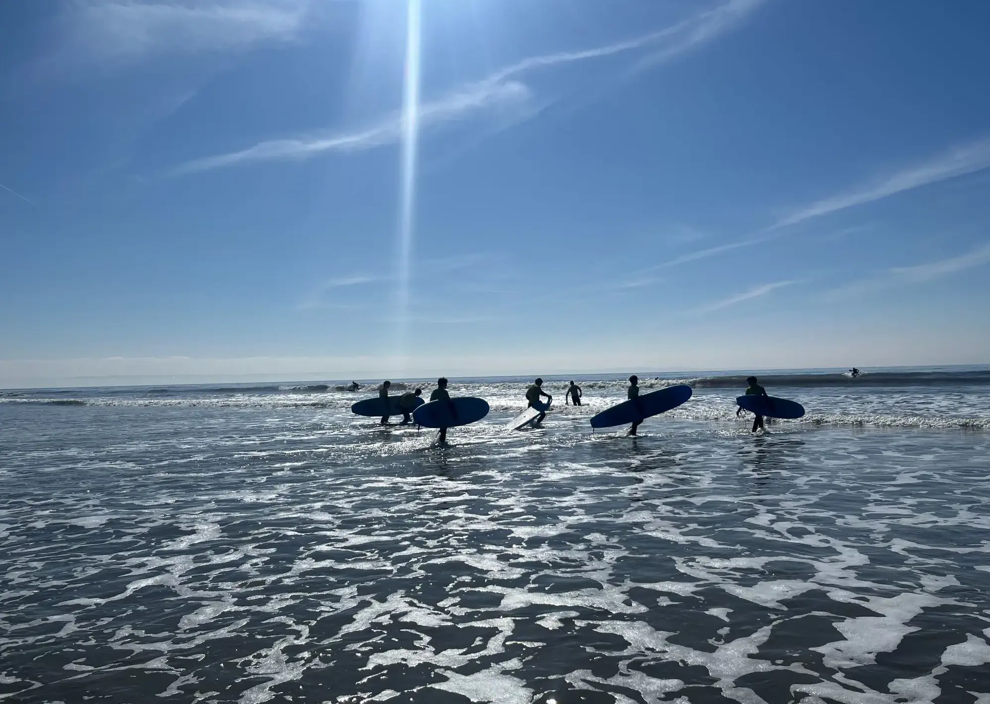 surfers heading into sea