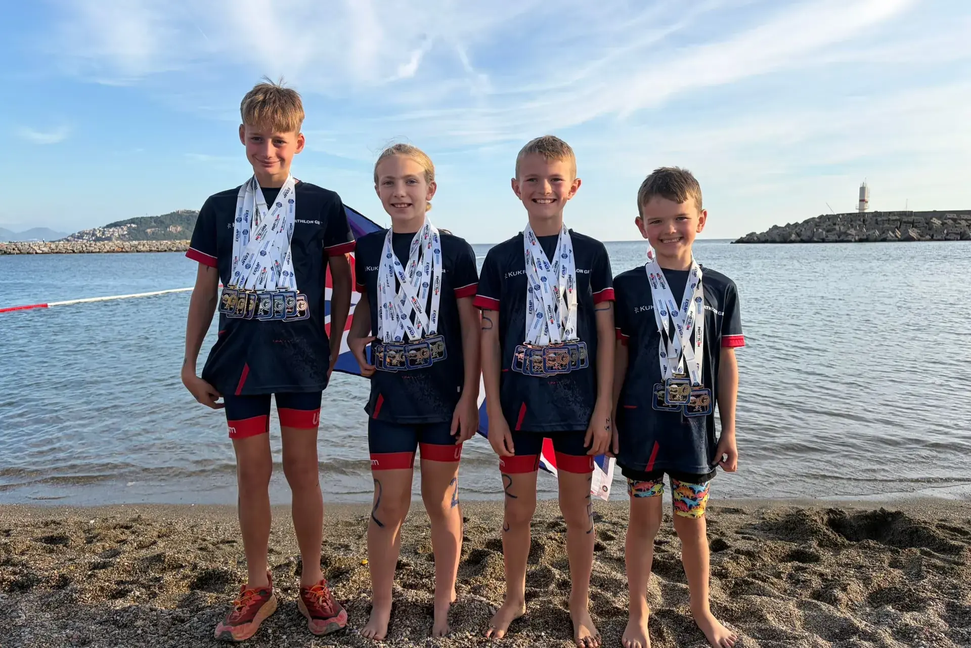 four boys covered in medals