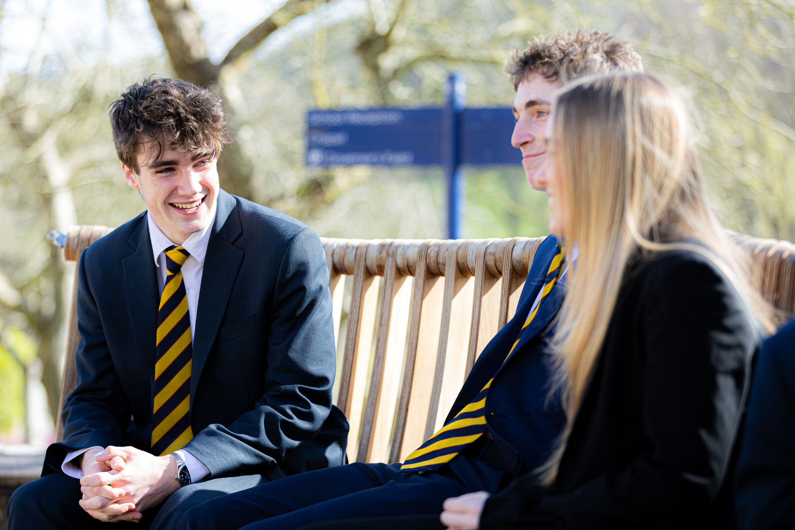 boys and girl talking on bench