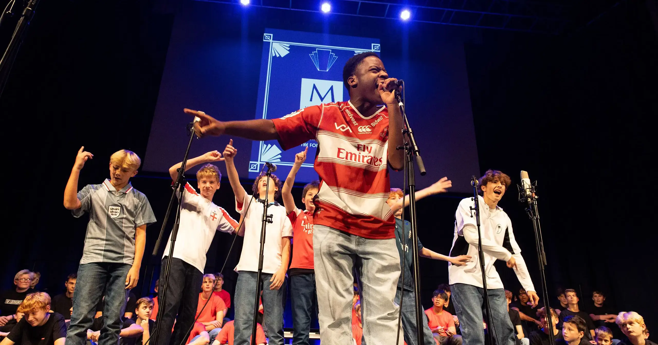 Male students singing on stage