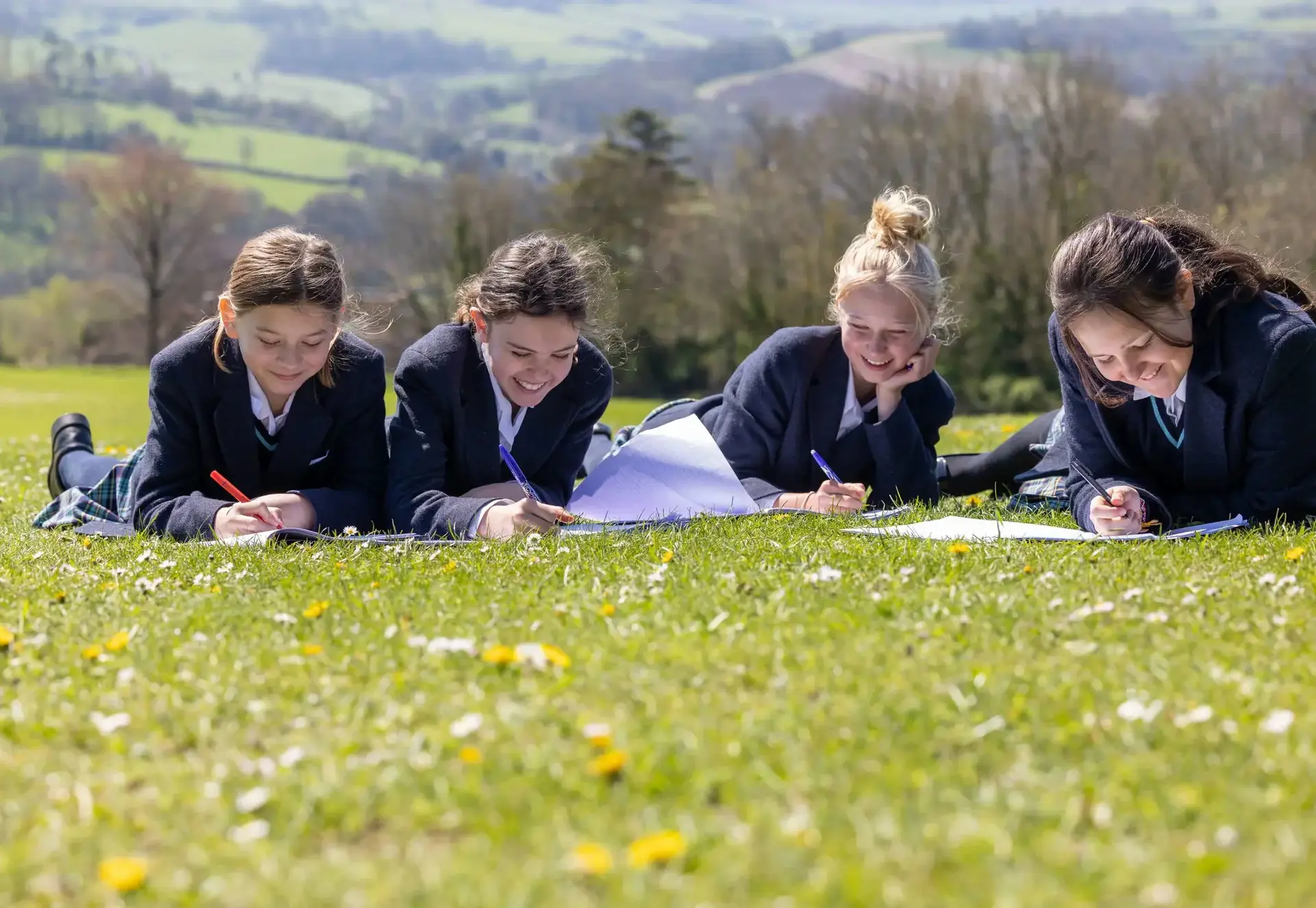 girls writing on the grass