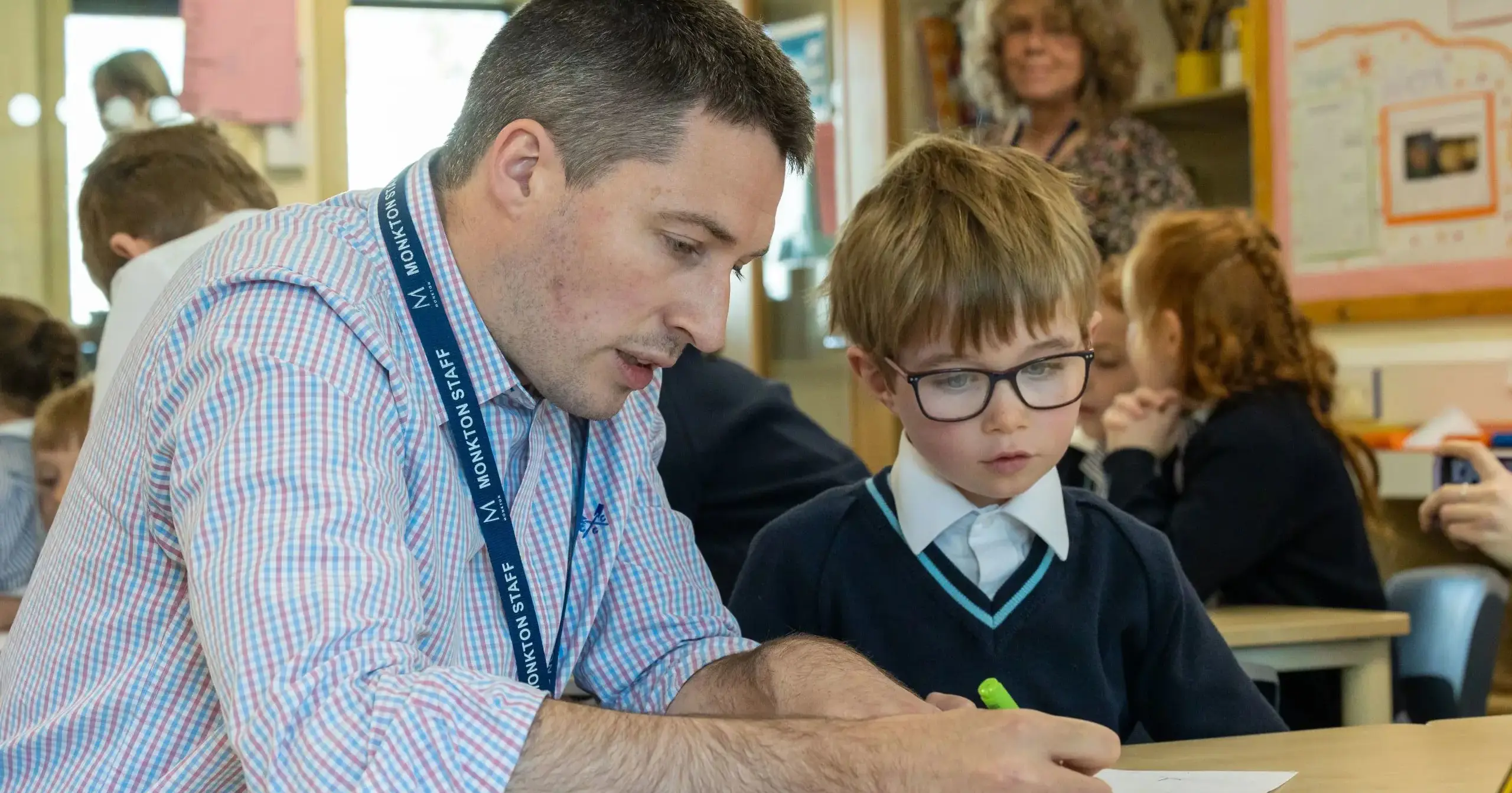 Male teaching helping student with work