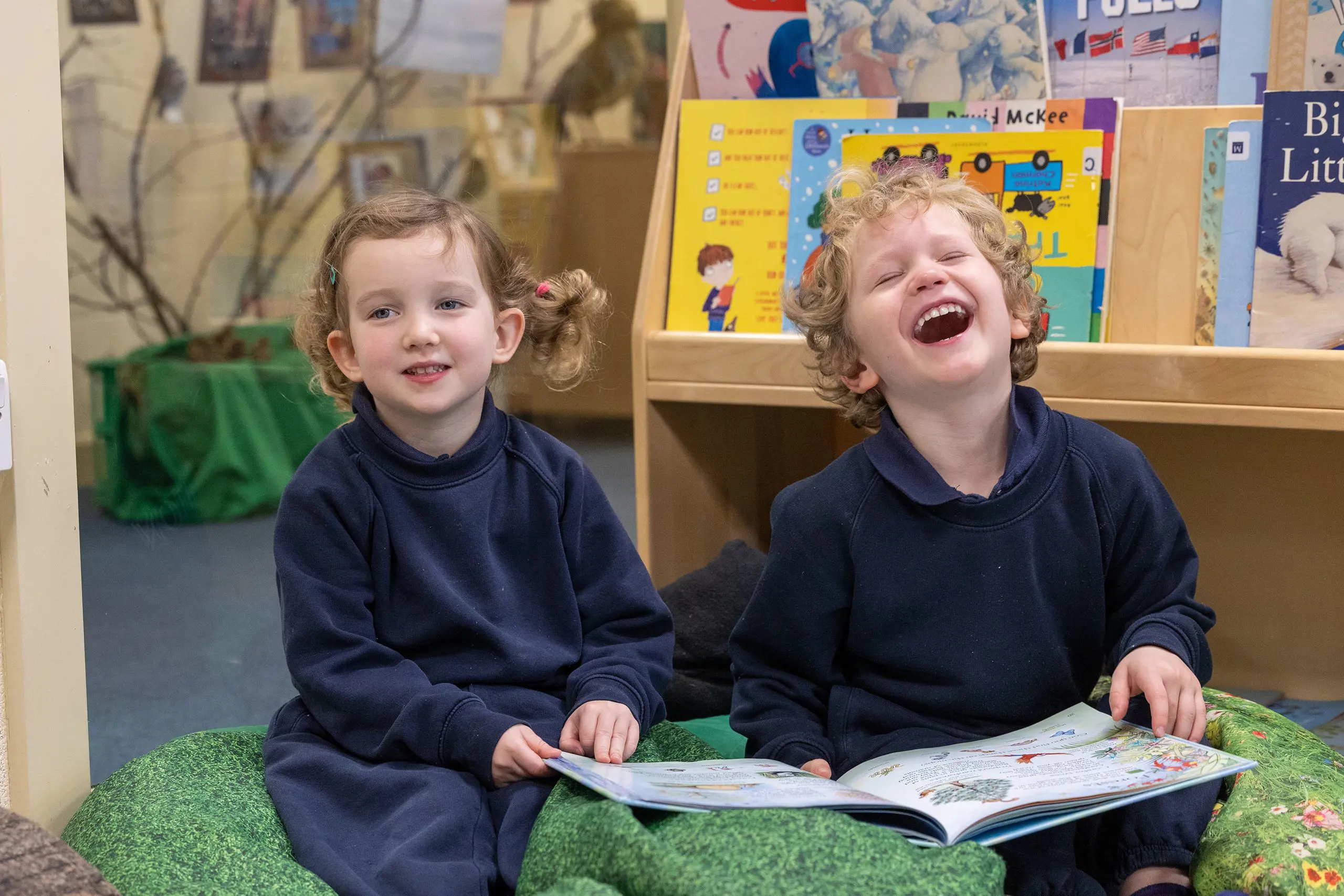Boy and girl reading a book and smiling