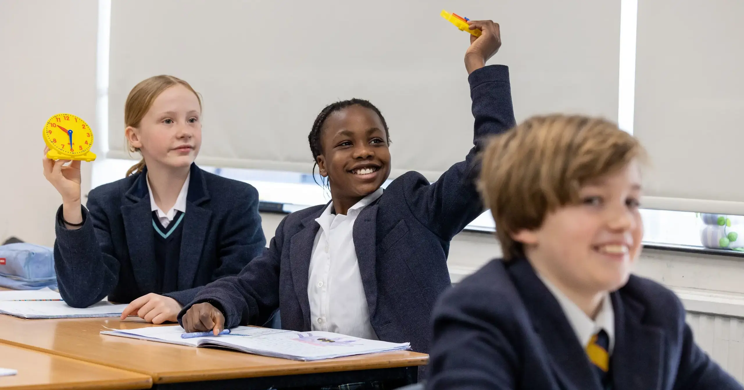 Students with hands up in class