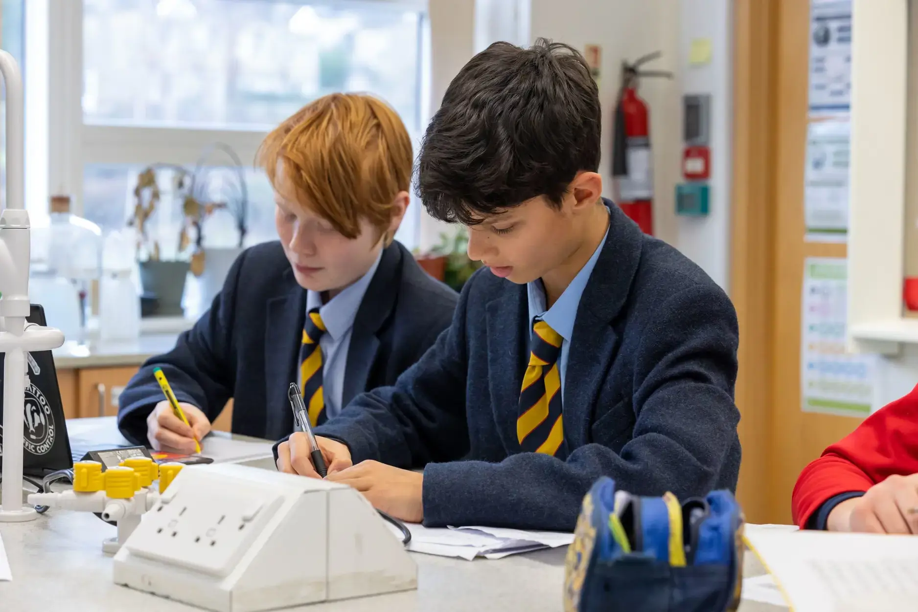 two boys writing at desk