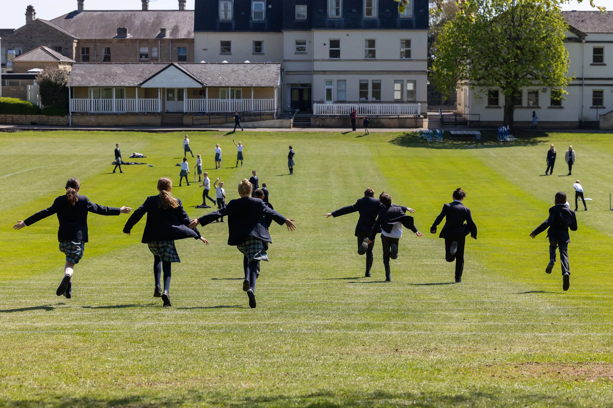 Children running in open green field
