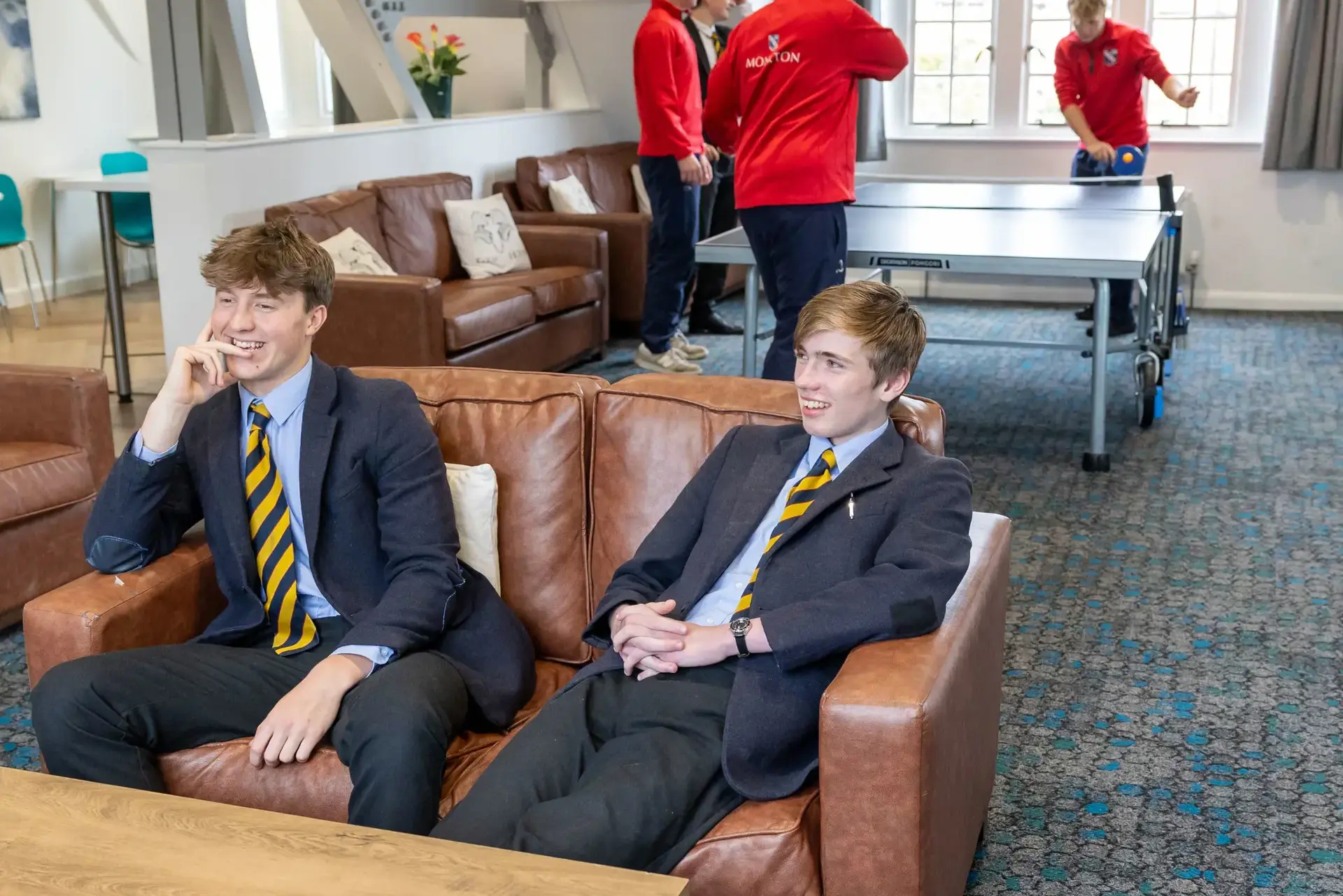 Group of boys playing table tennis and chatting