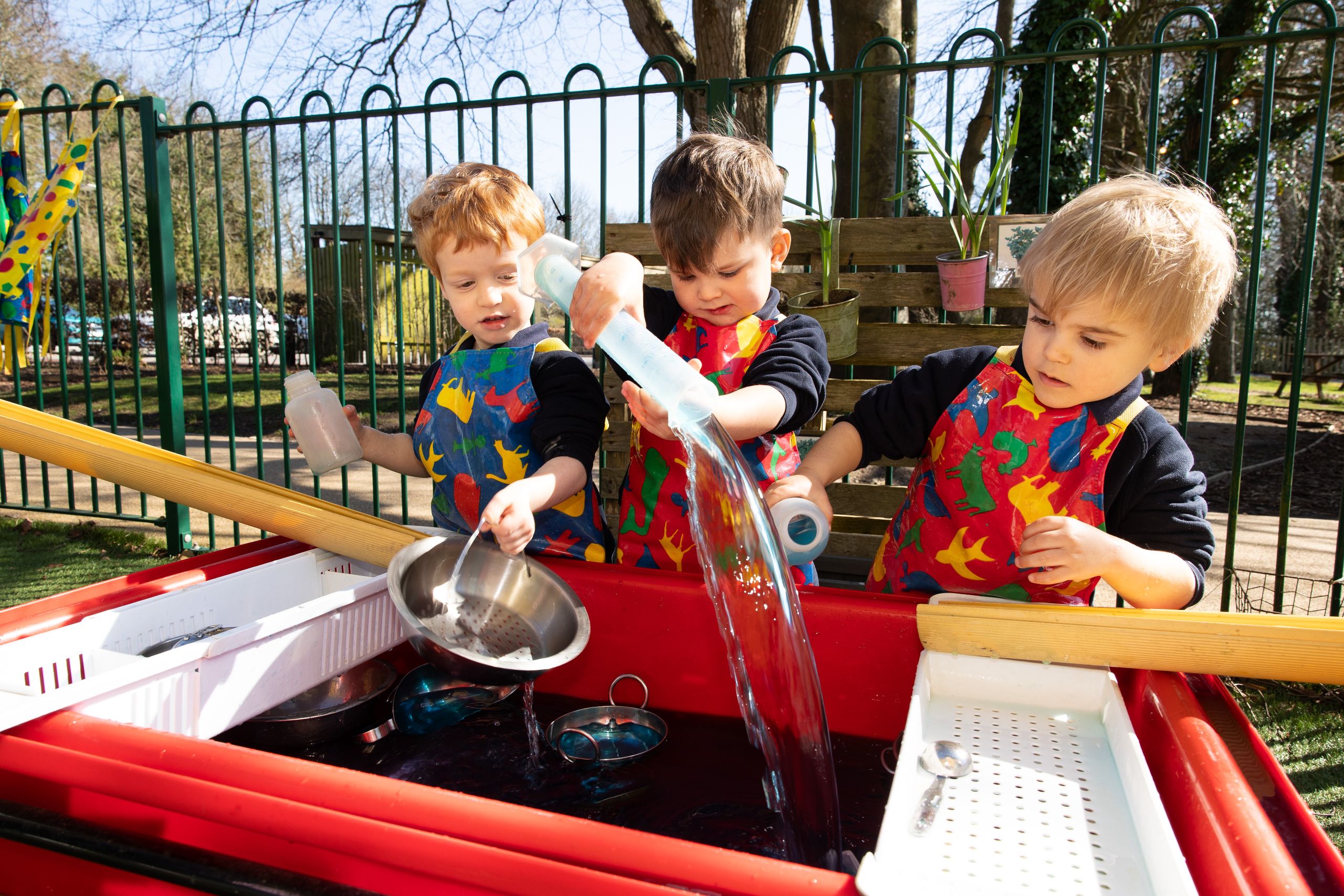 three boys playing with water