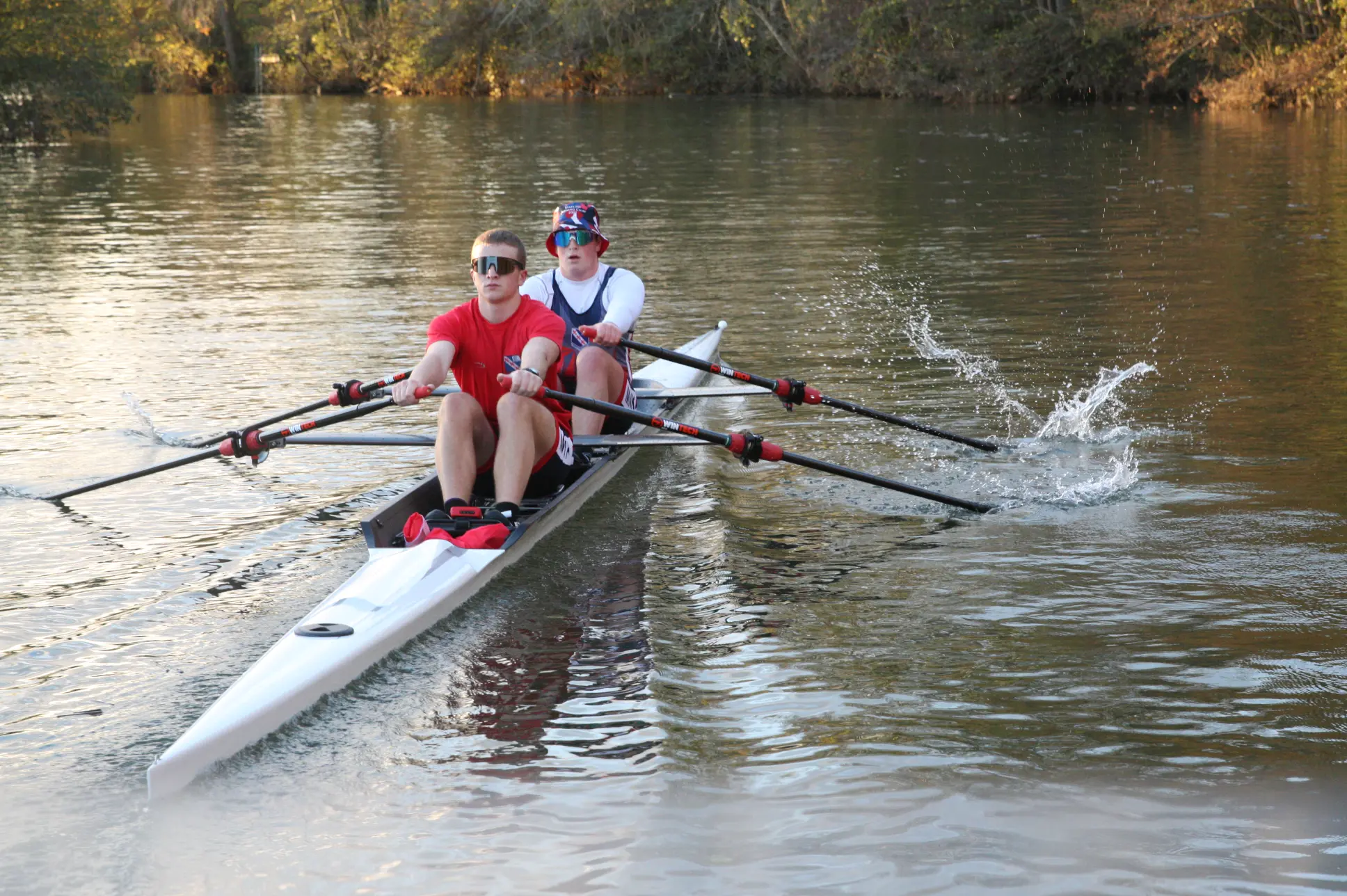 Boys rowing on river