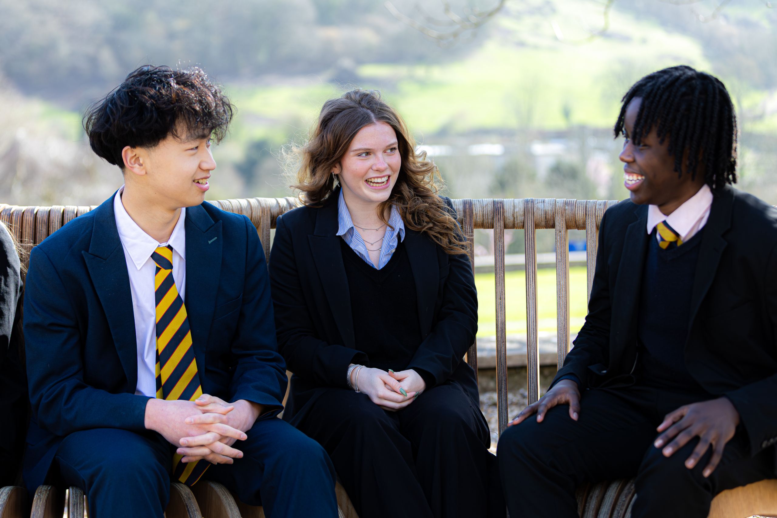 two boys and a girl sat on a bench