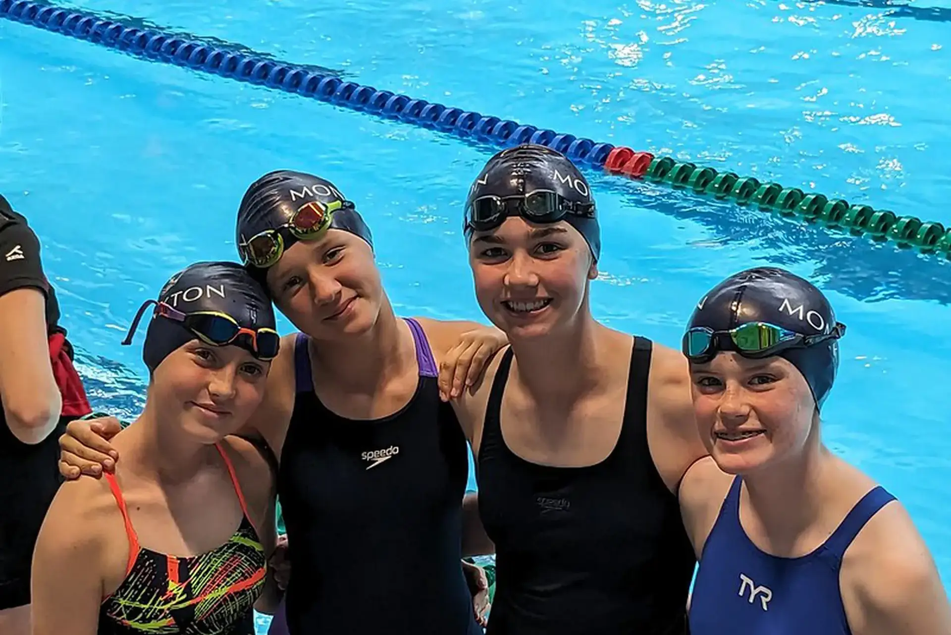 Students smiling together by the swimming pool